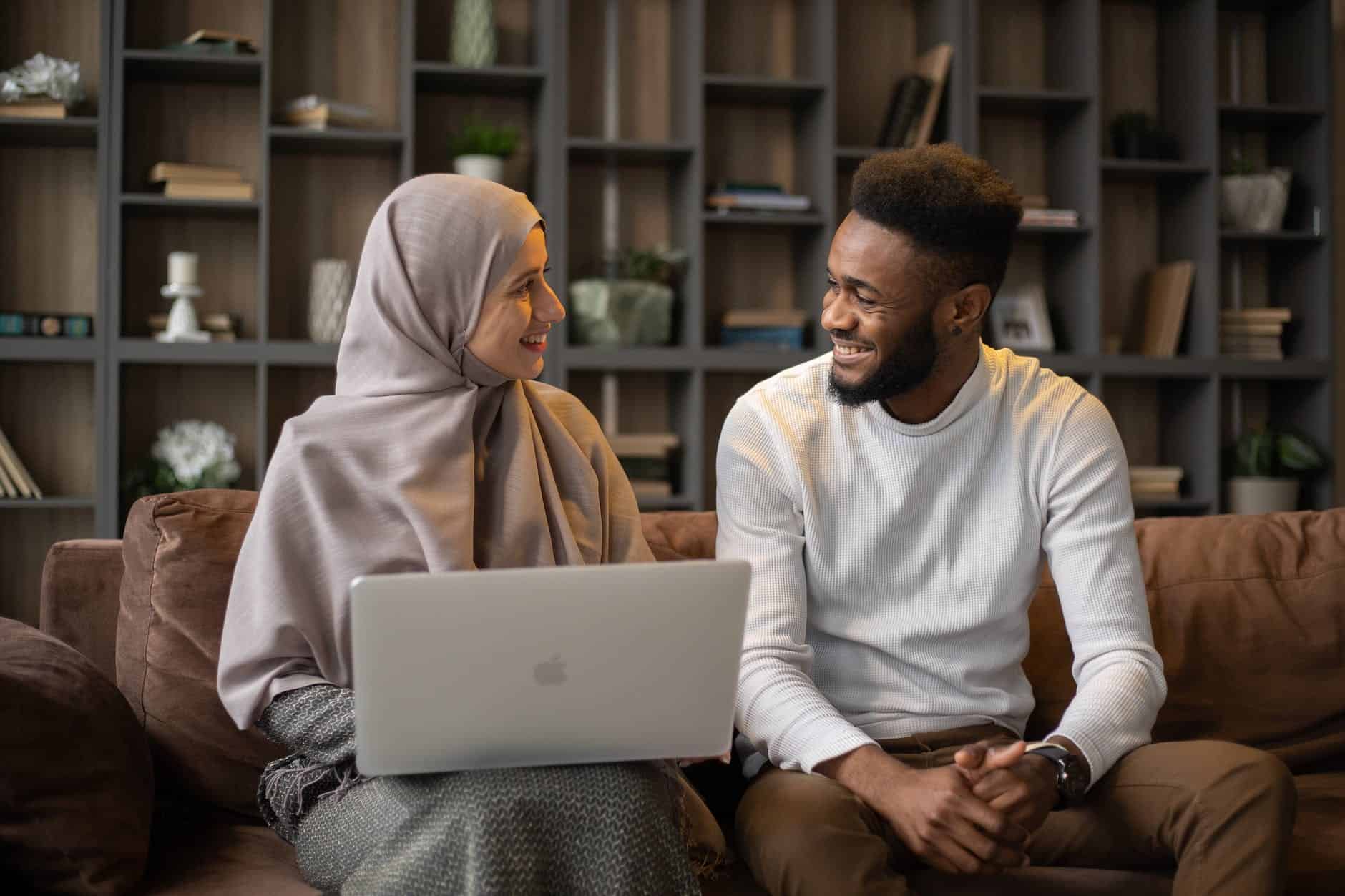 satisfied couple on sofa using laptop