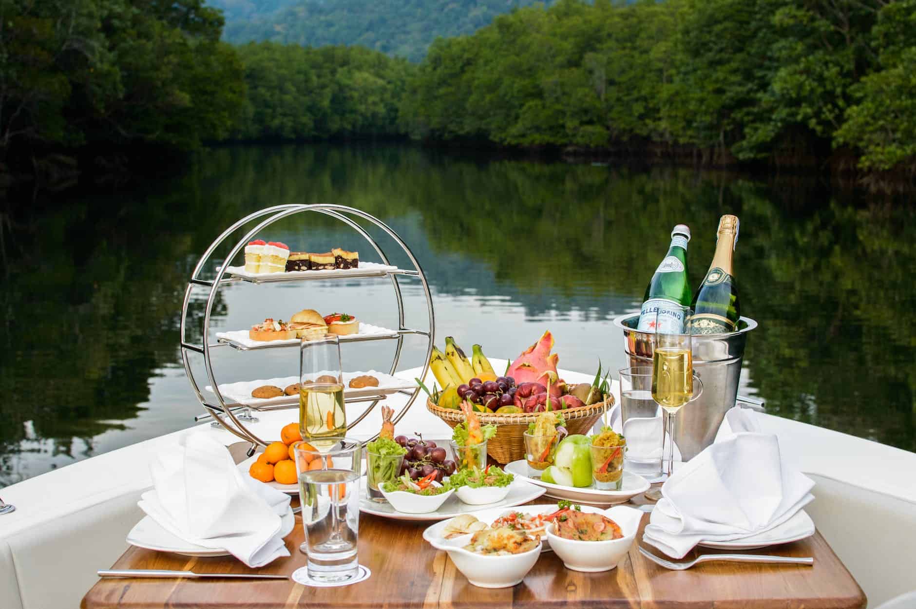 food photography of food and wine bottles on table inside boat