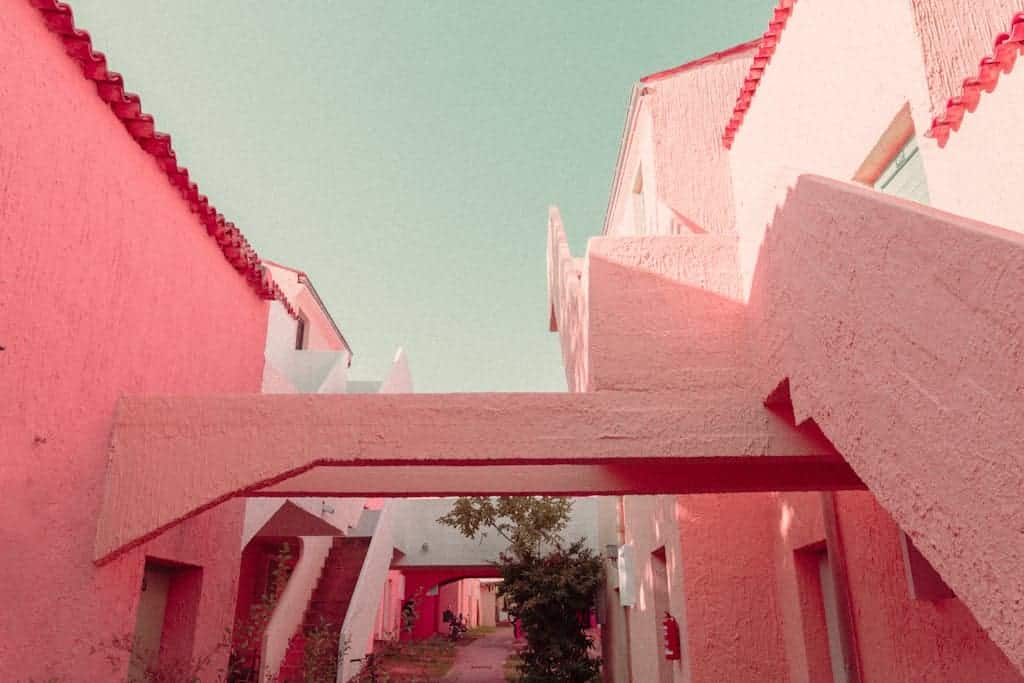 A pink building with a pink sky and a pink path