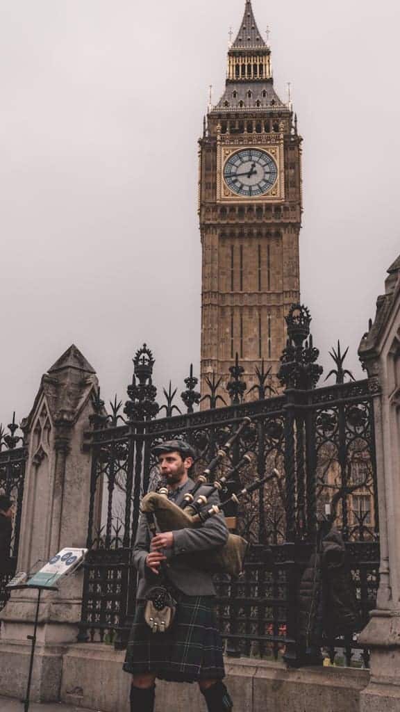 A man in a kilt and a dog in front of big ben