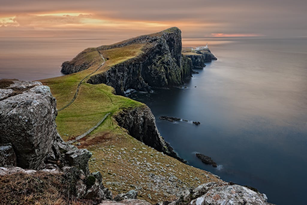 Green and Brown Mountain Cliffs Near Ocean