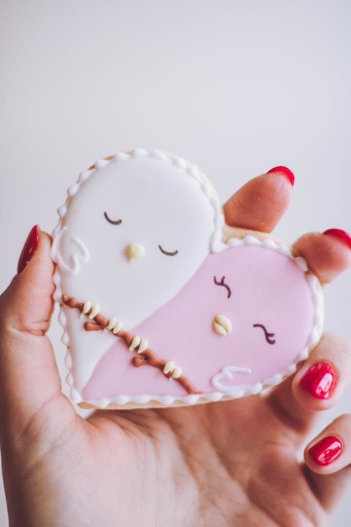 Person Holding White and Pink Heart Figure