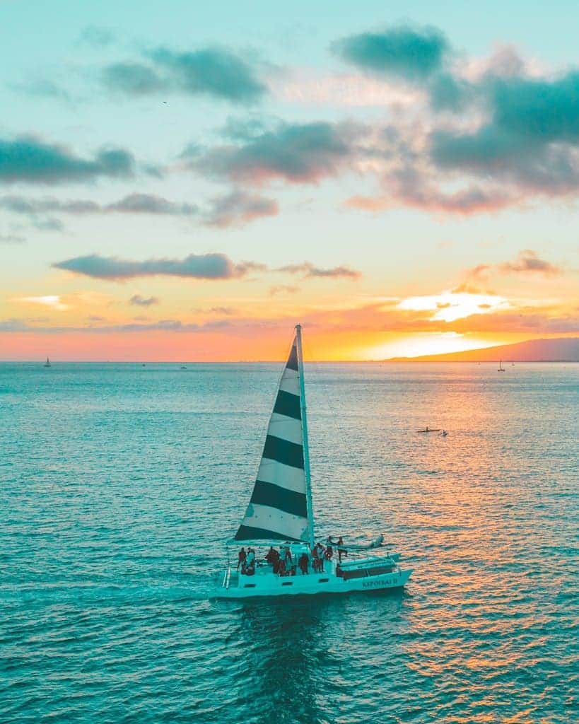 White and Blue Sailboat on Sea Under White Clouds and Blue Sky