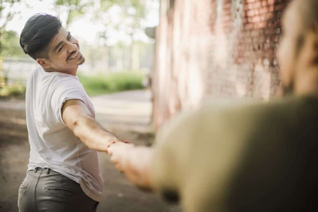 Man Looking Back and Holding Another Person's Hand