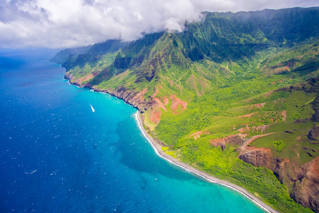 A captivating view of Hawaii's Na Pali Coast with vibrant blue ocean and lush mountains.