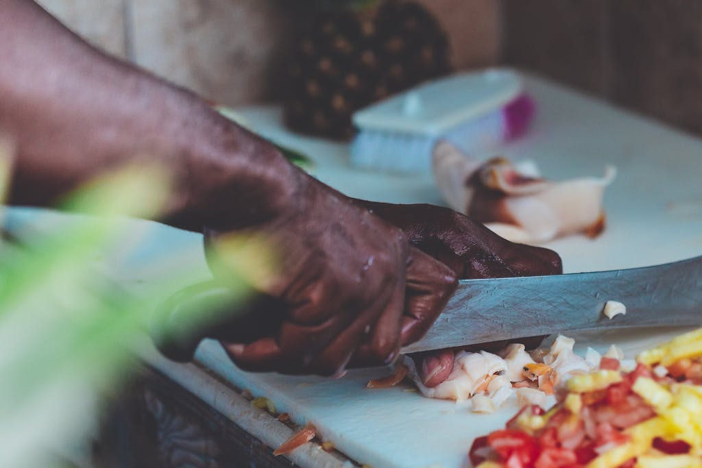 Close-up of a chef chopping fresh ingredients indoors in Nassau, Bahamas.