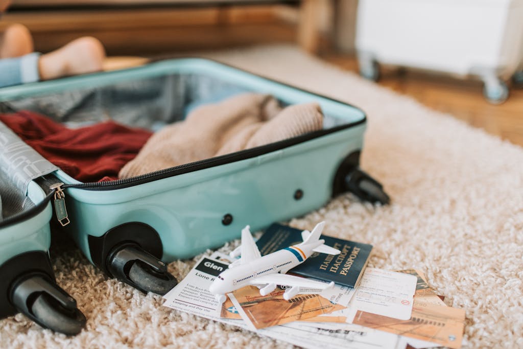 Close-up of an open suitcase with travel essentials like passport and tickets, ready for a journey.