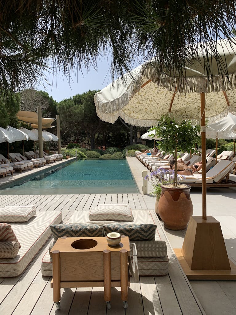 Elegant poolside setting with sun loungers and umbrellas, ideal for relaxation.